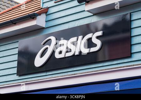 Cannock, Staffordshire, Royaume-Uni – 9 septembre 2025 : logo d'Asics, une multinationale japonaise de vêtements de sport dans un magasin d'usine Banque D'Images