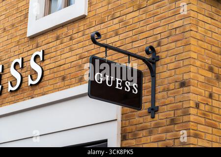 Cannock, Staffordshire, Royaume-Uni – 9 septembre 2025 : signalétique externe de Guess, une marque de vêtements américaine dans un magasin d'usine Banque D'Images