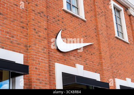Cannock, Staffordshire, Royaume-Uni – 9 septembre 2025 : logo de Nike, une entreprise de vêtements de sport dans un magasin d'usine Banque D'Images