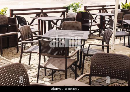 Terrasse de café extérieure avec tables et chaises. Vider le mobilier du restaurant à l'extérieur. Restaurant de rue le jour ensoleillé. Café urbain moderne. Banque D'Images