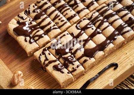 Barres protéinées maison sans cuisson faites à base de poudre de protéines de lactosérum et de beurre de noix enrobé de chocolat Banque D'Images