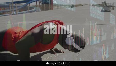 Homme push-ups performant portant un maillot d'entraînement rouge sur un terrain de basket-ball, avec panier, recouvrement financier Banque D'Images