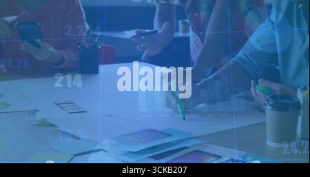 Collaboration des membres de l'équipe annotant des maquettes d'applications dans la salle de réunion, avec des surligneurs de smartphone Banque D'Images