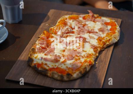 pinza fraîche maison avec mozzarella et jambon sur un plateau en bois. Cuisine italienne traditionnelle. Pizza dans un restaurant Banque D'Images