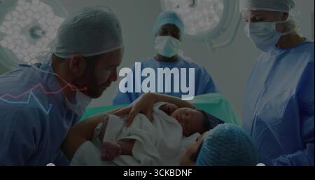 Remise du nouveau-né enveloppé dans une couverture par le père à l'hôpital à la mère, avec table d'opération, lumières. Famille, santé, maternité, maternité, service de maternité, médecin Banque D'Images