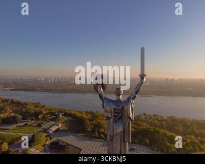 Le Monument de la mère patrie à Kiev, en Ukraine, vu de derrière, tient une épée et un bouclier avec les armoiries ukrainiennes, surplombant la rivière Dnipro A. Banque D'Images