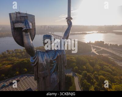 Le Monument de la mère patrie à Kiev, en Ukraine, vu de derrière, tenant une épée et un bouclier avec les armoiries ukrainiennes, avec le fleuve Dnipro et la ville Banque D'Images
