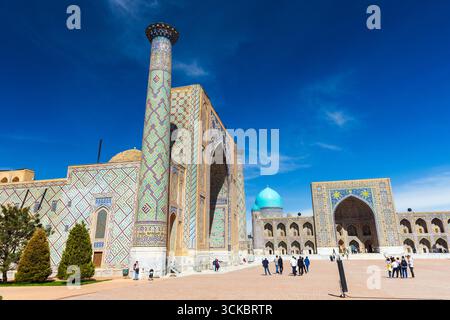 Samarcande, Ouzbékistan - 25 mars 2024 : les touristes sont sur la place du Registan par une journée ensoleillée. Ulugh Beg Madrasah, Tilya-Kori Madrasah sont sur le backgro Banque D'Images
