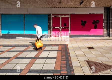 Un homme senior de passage a fermé des magasins à l'intérieur du centre commercial Weaver Square à Northwich, Cheshire Royaume-Uni Banque D'Images