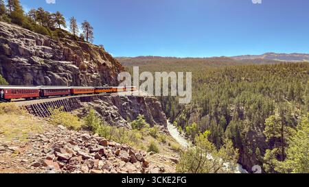 Durango, Colorado, États-Unis - 23 mai 2025 : train sur le chemin de fer à voie étroite Durango et Silverton passant devant une rivière et une gorge dans un paysage pittoresque Banque D'Images