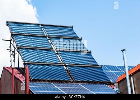 Le toit d'une maison économe en énergie avec panneaux solaires et chauffe-eau solaires. Banque D'Images