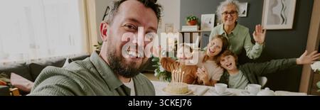En-tête de l'homme caucasien prenant Selfie avec la famille multi-générationnelle célébrant l'anniversaire Banque D'Images
