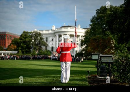 Washington, États-Unis. 11 septembre 2025. Une garde d'honneur militaire salue alors que le drapeau est abaissé en Berne alors que le personnel de la Maison Blanche se réunit pour un moment de silence après le meurtre du militant de droite Charlie Kirk sur la pelouse sud de la Maison Blanche, le 11 septembre 2025 à Washington, DC Kirk, un provocateur conservateur et ami proche du président Donald Trump a été abattu lors d'un événement politique dans l'Utah. Crédit : Molly Riley/White House photo/Alamy Live News Banque D'Images
