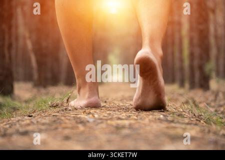 Gros plan jambes de l'homme se promenant dans la forêt sur fond de soleil brillant. Concept mode de vie sain et fitness Banque D'Images