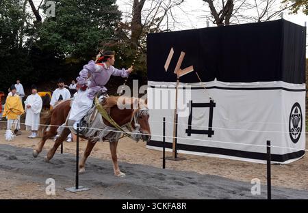 Des archers japonais sur des flèches à cheval tirant sur une cible en bois lors d'un tir à l'arc monté appelé yabusame (流鏑馬 ?) à Hikone, Shiga, Japon. Banque D'Images