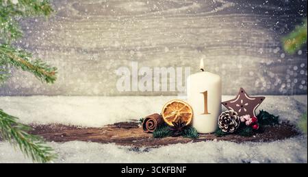 Décoration de l'Avent avec bougie allumée, écorce, citron séché, pommes de pin, branches de sapin, Bowla, et étoile à Snowfall, 1er Avent, composition Banque D'Images