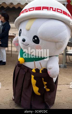 Mascotte japonaise yuru-kyara personnages de culture populaire Sanomaru (bol à soupe sur la tête et tenant le kushikatsu) lors d'un événement à Hikone, Shiga, Japon. Banque D'Images