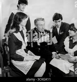 Une « réunion de générations » à l'école secondaire n ° 12 à Sloviansk à la fin des années 1970 Le voenruk (instructeur militaire) de l'école, un vétéran de la marine décoré dans son uniforme complet avec des médailles, donne une « leçon de courage » aux élèves du secondaire. Les élèves, vêtus d'uniformes scolaires soviétiques standard avec un badge Komsomol, écoutent ses histoires de guerre. Cette image est symbolique du vaste système d'éducation patriotique pour les jeunes qui était une pierre angulaire de la société en URSS pendant l'ère Brejnev Banque D'Images