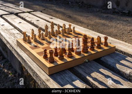 Scène de parc urbain avec échiquier installé sur un banc en bois, mélangeant loisirs, culture, pleine conscience. Un moment paisible dans la vie urbaine axé sur la logique A. Banque D'Images
