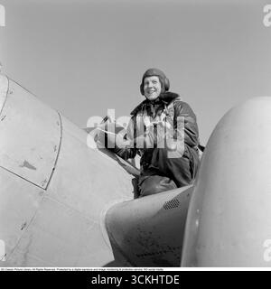 Birgit Thüring : aviateur suédois pionnier. Dans cette image de 1958 Birgit Thüring (1912-1984) dans ses combinaisons de vol sur son avion. Servant de pilote de cible, remorquant des banderoles pour la pratique du tir de la force aérienne, elle a fait preuve de précision et de courage dans un rôle essentiel. En tant que femme aviatrice pionnière dans un domaine dominé par les hommes, la présence de Birgit sur la base aérienne éloignée de Gotland reflète les premiers pas de la Suède vers l’égalité des sexes dans l’aviation militaire. Conard ref 3684 Banque D'Images