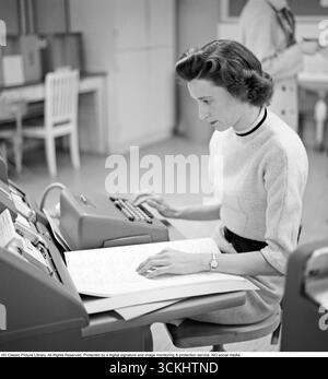 Jeune femme au travail : calculer à son bureau, 1960 Une employée de bureau est assise et compte sur une calculatrice. Kristoffersson réf CP47-2 Banque D'Images