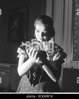 Diseuse de bonne fortune. Une femme qui tient une boule de cristal et prévoit l'avenir. Le regard de boule de cristal, une forme de divination, implique un voyant utilisant une sphère de verre pour prévoir des événements futurs ou obtenir des idées spirituelles. Populaire dans diverses cultures, il est souvent associé au mysticisme et à la révélation de fortune, captivant ceux qui cherchent des conseils ou intrigués par l’occulte. Suède 1950 Kristoffersson ref AY60-7 Banque D'Images