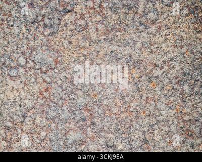 Gros plan de la surface en pierre de granit naturel avec texture multicolore rugueuse. Photo de haute qualité Banque D'Images
