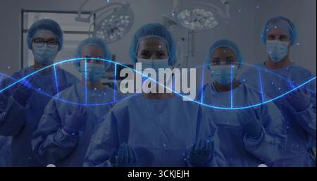 Debout cinq chirurgiens portant une tenue chirurgicale dans la salle d'opération, avec superposition double hélice ADN Banque D'Images