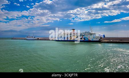 Un ferry Moby Lines dans le port de Toscane. En arrière-plan - ciel bleu et nuages blancs, au premier plan brillante mer émeraude. 28 septembre 2024. L Banque D'Images