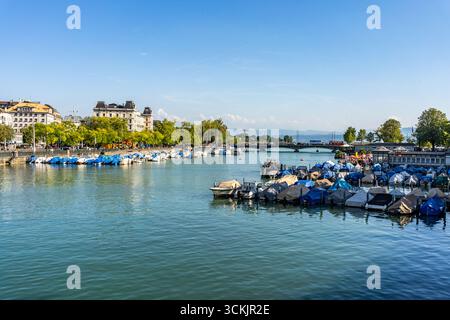 Vue panoramique sur la rivière Limmat avec des bateaux amarrés par une journée d'été ensoleillée, au cœur de Zurich, Suisse. Banque D'Images