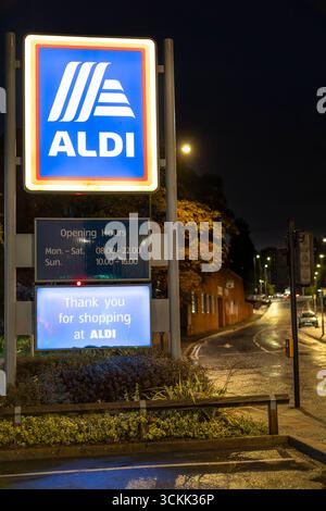 Gros plan d'un grand panneau publicitaire extérieur pour un supermarché Aldi au Royaume-Uni, illuminé la nuit. Banque D'Images