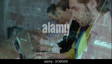 Homme barbu dans Blazer examinant le graphique sur ordinateur portable dans le bureau de trading avec superposition de données, espace de copie Banque D'Images
