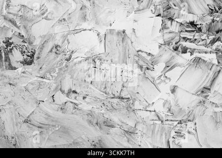 Pâte de mastic mélangée à de l'encre noire, détail abstrait gros plan des coups de spatule sur la rénovation de stuc Banque D'Images