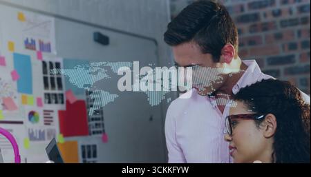 Deux collègues examinant les données sur ordinateur portable affichant la carte numérique dans l'espace de travail de bureau, espace de copie Banque D'Images