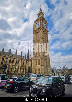 LONDRES, ROYAUME-UNI - 15 AVRIL 2023 Une scène de rue londonienne animée avec l'emblématique Elizabeth Tower, maison de Big Ben. Taxis noirs classiques Banque D'Images