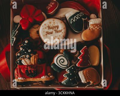 Biscuits festifs en pain d'épices dans une boîte cadeau de vacances. Un assortiment de biscuits en pain d'épices magnifiquement décorés en forme de symboles de Noël, prêts pour Banque D'Images