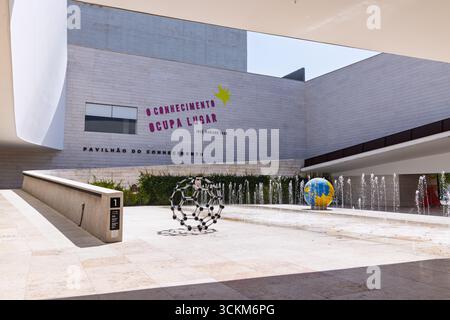 La façade du Pavillon de la connaissance présente le nom en portugais et une citation. La cour extérieure présente des sculptures modernes et une fontaine globe. Li Banque D'Images