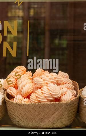 28 août 2025, Bruges, Belgique — tourbillons de guimauve orange vif disposés dans un panier en osier dans un magasin. Banque D'Images