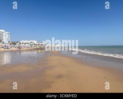 Sables dorés de Playa de la Costilla à Rota, avec des eaux calmes de l'Atlantique, des promenades, des bains de soleil et des chiringuitos vibrants ciel ensoleillé clair. Espagne Banque D'Images