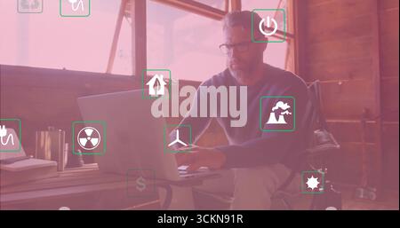 Homme mature travaillant tapant sur ordinateur portable dans le bureau rustique, avec des icônes de tasse et d'énergie, espace de copie Banque D'Images