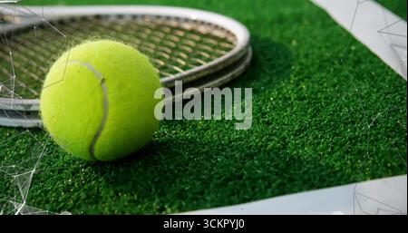 Balle de tennis jaune reposant sur un gazon vert près de la ligne de limite blanche, avec raquette métallique, espace de copie Banque D'Images
