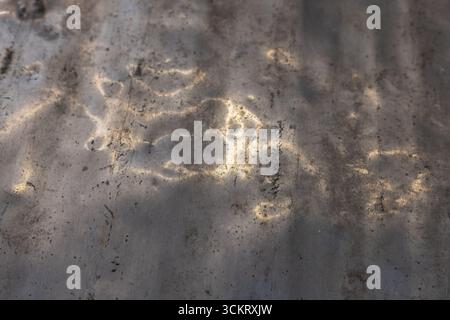 La surface en aluminium texturé présente des reflets lumineux et des rayures dans un environnement extérieur industriel. Banque D'Images