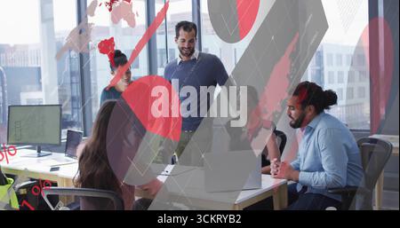 Cinq membres de l'équipe examinant les tableaux numériques et se penchant sur le bureau lors d'une réunion de bureau, avec des ordinateurs portables Banque D'Images