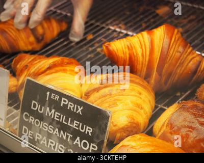 Croissants frais et pain au chocolat exposés dans une vitrine de boulangerie parisienne Banque D'Images