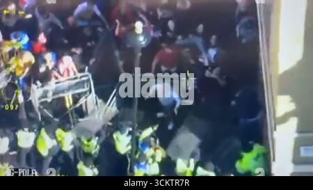 Capture d'écran DE LA MEILLEURE QUALITÉ DISPONIBLE tirée d'une vidéo publiée par la police métropolitaine sur son compte X montrant des policiers (en bas à gauche) empêchant une foule de manifestants « Unite the Kingdom » tentant d'entrer dans la zone stérile de Whitehall, où la marche et le rassemblement dirigés par Tommy Robinson, et la marche contre le fascisme, organisée par Stand Up to Racism (SUTR), convergent dans le centre de Londres. Date de la photo : samedi 13 septembre 2025. Banque D'Images