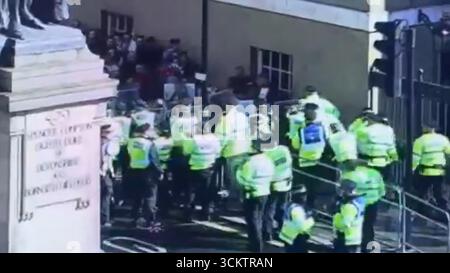 Capture d'écran DE LA MEILLEURE QUALITÉ DISPONIBLE tirée d'une vidéo postée par la police métropolitaine sur son compte X montrant des policiers empêchant une foule de manifestants « Unite the Kingdom » tentant d'entrer dans la zone stérile de Whitehall, où la marche et le rassemblement dirigés par Tommy Robinson, et la marche contre le fascisme, organisée par Stand Up to Racism (SUTR), convergent dans le centre de Londres. Date de la photo : samedi 13 septembre 2025. Banque D'Images
