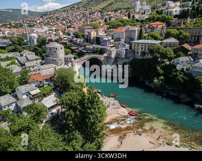 Photo drone de Stari Most à Mostar, Bosnie-Herzégovine, montrant la rivière Neretva avec des bateaux de tourisme, Muzej Stari Most, la mosquée Koski Mehmed Pacha Banque D'Images