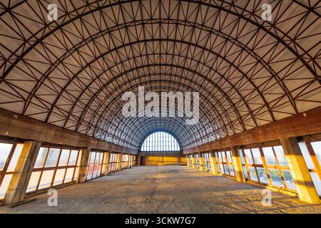 Vue intérieure d'un bâtiment industriel inachevé avec une grande structure de toit en treillis d'acier voûté et de vastes baies vitrées. Le Symmetri Banque D'Images