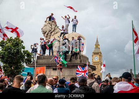 Manifestants sur l'un des lions sur le pont de Westminster, la marche « Unite the Kingdom » menée par Tommy Robinson rassemble des centaines de milliers de manifestants en cent Banque D'Images