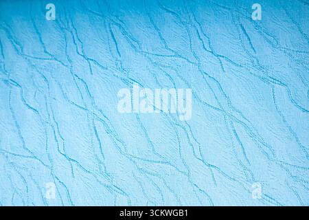 Fond de texture abstrait de tissu bleu avec un motif en relief ondulé, gros plan Banque D'Images